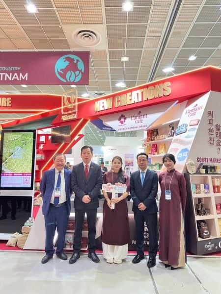 Đại sứ Vũ Hồ (thứ hai từ trái qua) chụp ảnh cùng đại diện L'amant Café tại Gian hàng Việt Nam.