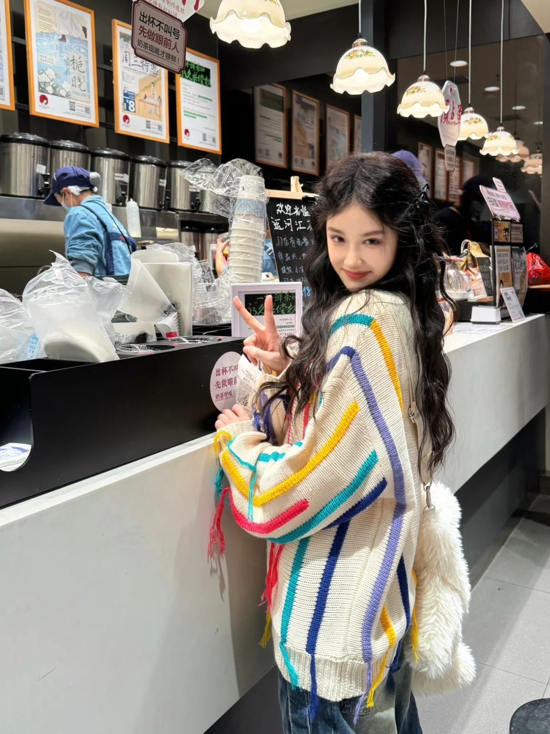 9. Tư thế tựa quầy bar, giơ tay chữ V tinh nghịch