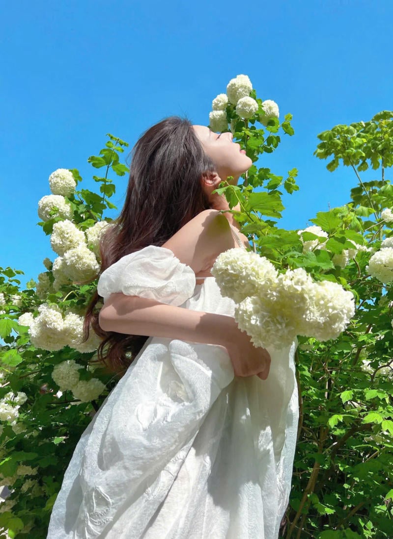 Đưa hoa lên ngang vai, mắt nhìn xa xăm