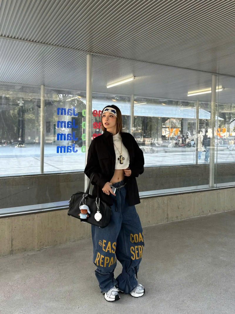 Áo khoác đen layering cùng crop top và quần jeans baggy họa tiết chữ