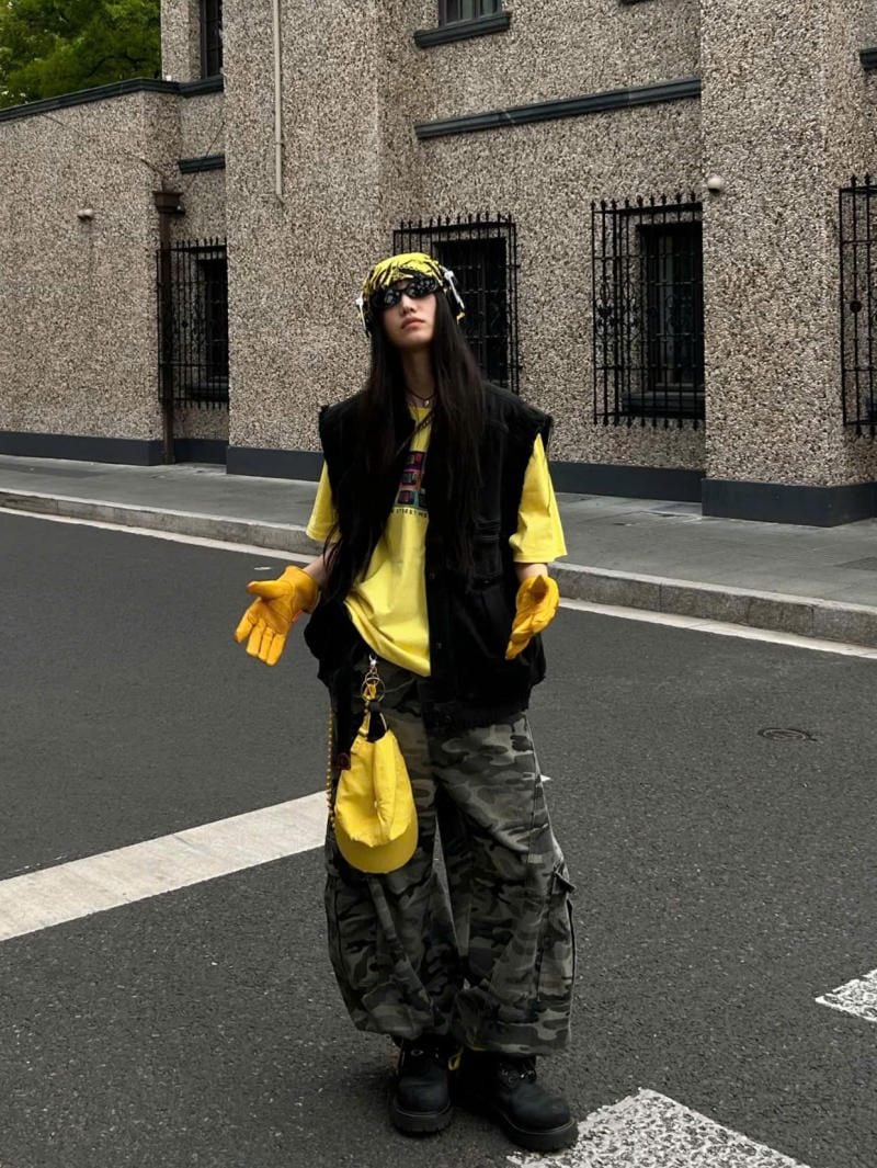 Áo gile đen layering áo thun vàng phối quần túi hộp rằn ri và phụ kiện đồng bộ