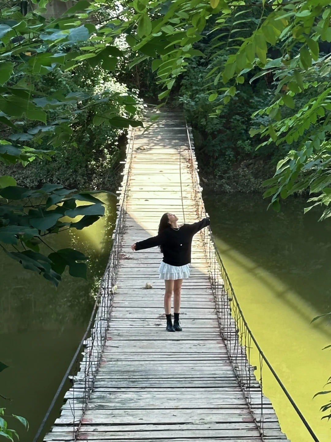 17. Tư thế đứng giữa cầu, dang rộng tay đón gió