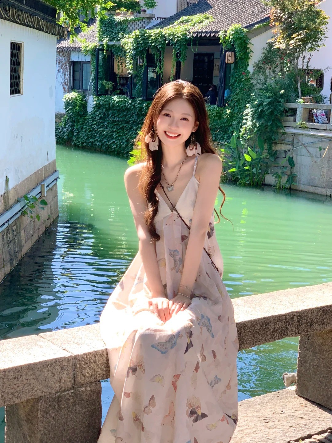 20. Tư thế ngồi trên thành cầu, hai tay ôm gối mỉm cười