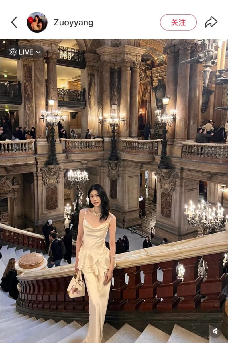 Đứng trên cầu thang lớn, khoe trọn bộ lễ phục