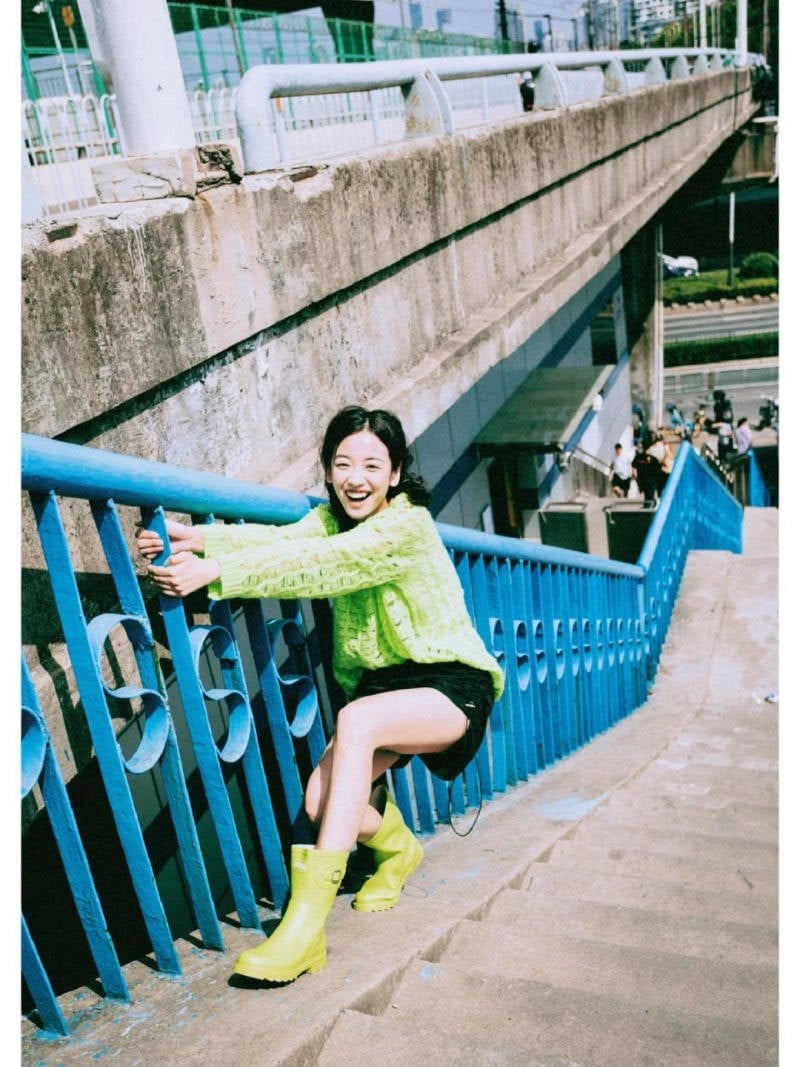 Tư thế ngồi xổm, ôm lan can và cười rạng rỡ