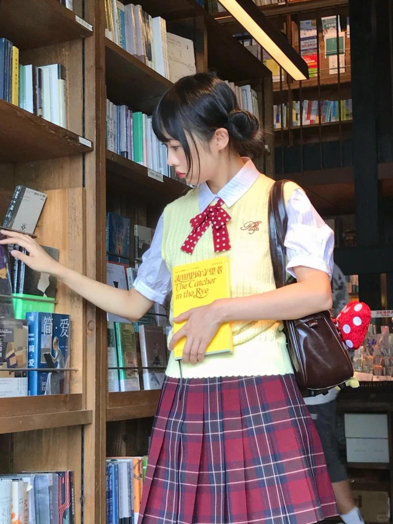 (tay chạm vào sách, người hơi nghiêng)