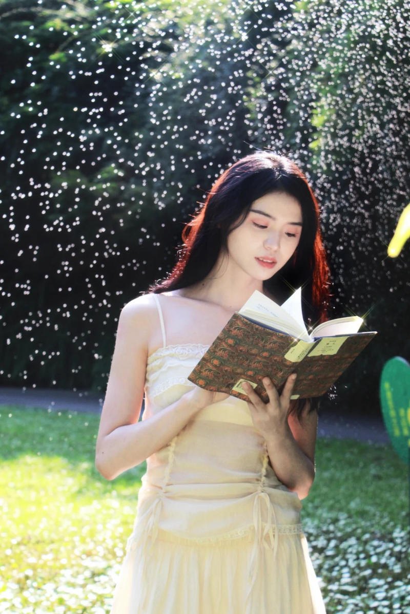 (đứng đọc sách, xung quanh là cây cỏ, ánh sáng huyền ảo)