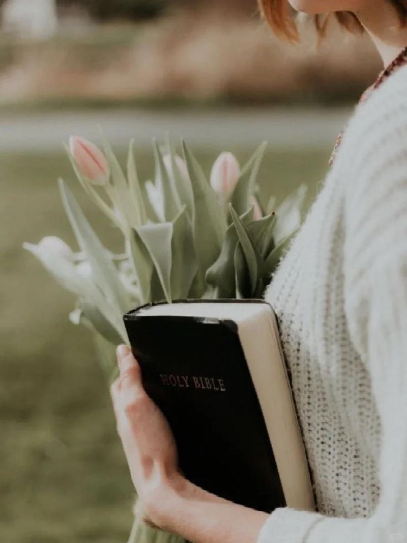 (chụp nửa người, tay cầm sách và hoa)