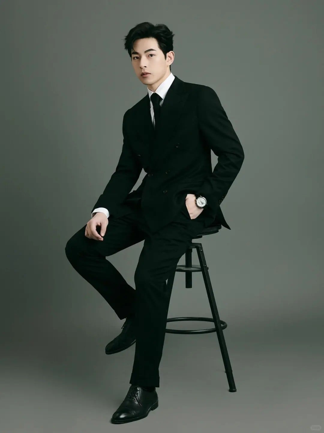 22. Tư thế ngồi trên ghế đẩu, tay trong túi quần