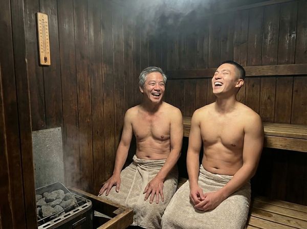 Cha và con trai trưởng thành cùng tận hưởng phòng xông hơi gia đình lâu đời.