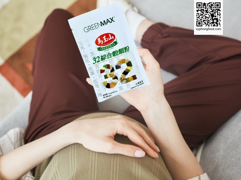 Young pregnant woman reading a book about “can pregnant women drink multi grains cereal”, Greenmax multi grains cereal branding visible, vyphongfood.com credit.