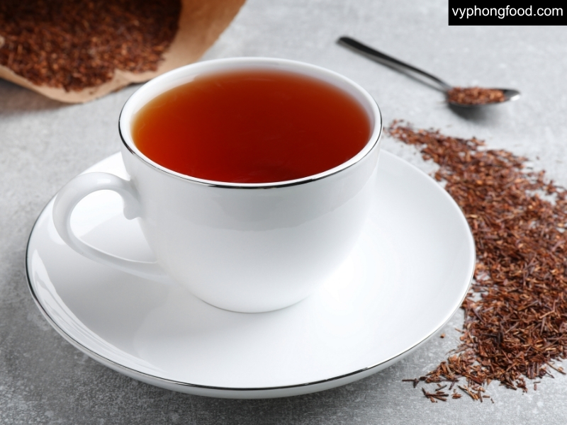người đang thưởng thức tách hồng trà rooibos african dawn nhập khẩu chính ngạch từ nam phi sau bữa ăn giúp hỗ trợ chức năng gan khỏe mạnh và giảm căng thẳng chuyển hóa