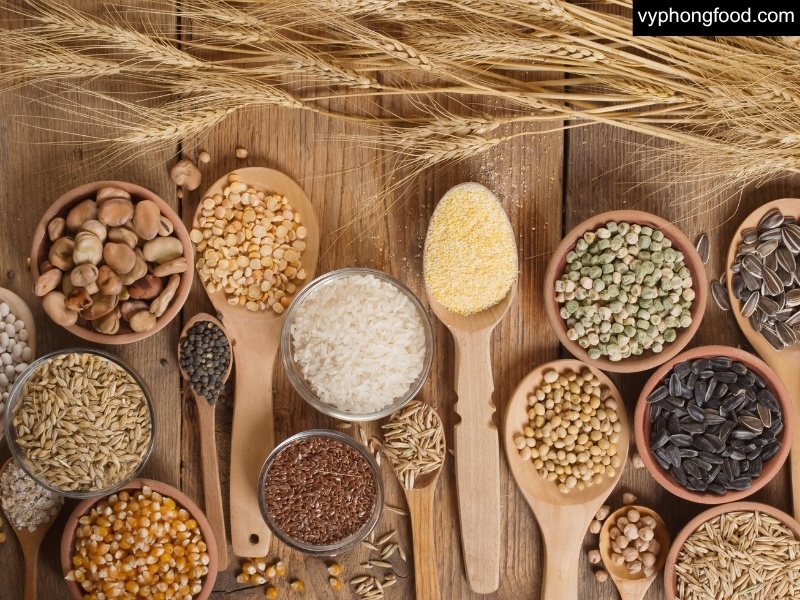 Four whole grains - oats, barley, brown rice, buckwheat - on a table; foods shown to help lower cholesterol and blood pressure.