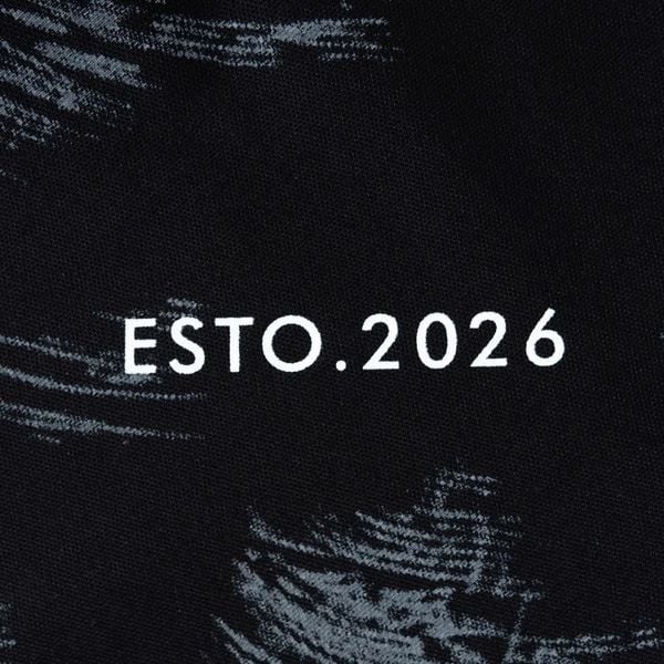Chi tiết chữ in ESTO.2026 trên áo polo đen họa tiết