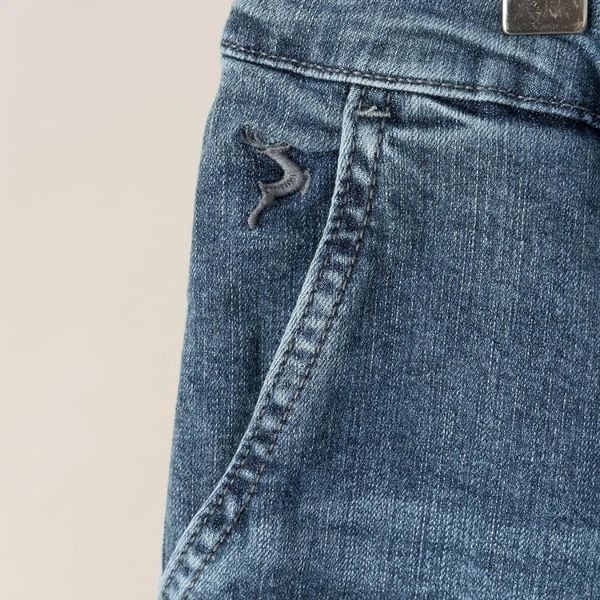 Chi tiết túi trước và logo thêu quần short jean xanh nam