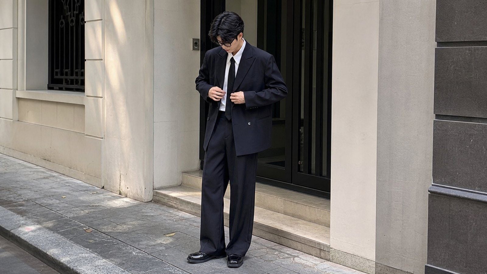 Nam giới kéo khóa áo, chỉnh blazer hoặc cài khuy để tạo khoảnh khắc