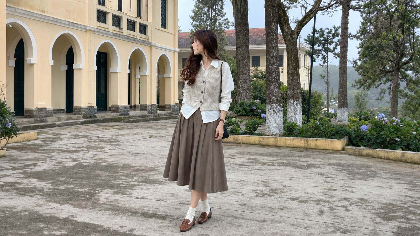 Sơ mi trắng phối gile len và chân váy midi mang hơi hướng preppy