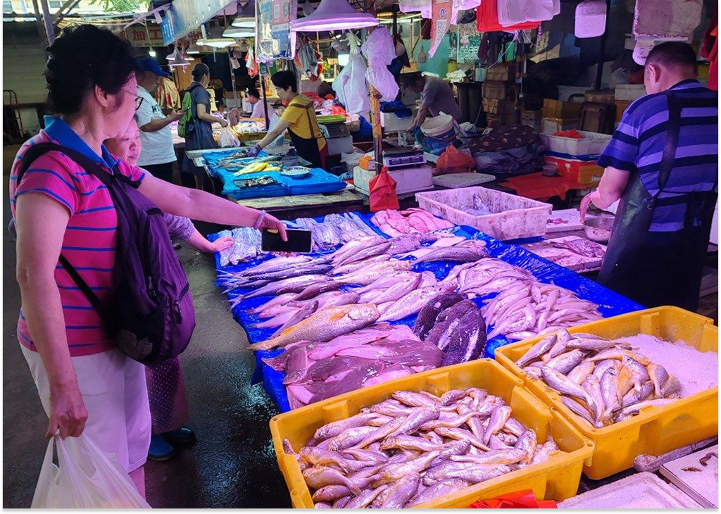 Du khách mua hải sản tươi tại chợ địa phương Thanh Đảo