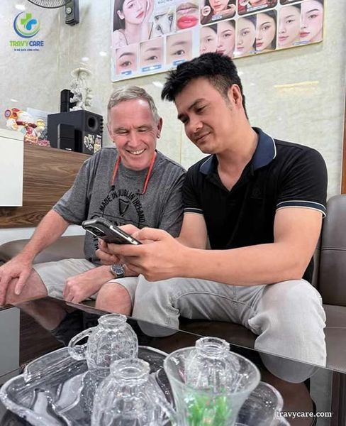 Một khách hàng quốc tế đang được chuyên viên tại Rio Beauty Clinic tư vấn trong khong gian sảnh cảu rio (có logo rio trên tường).