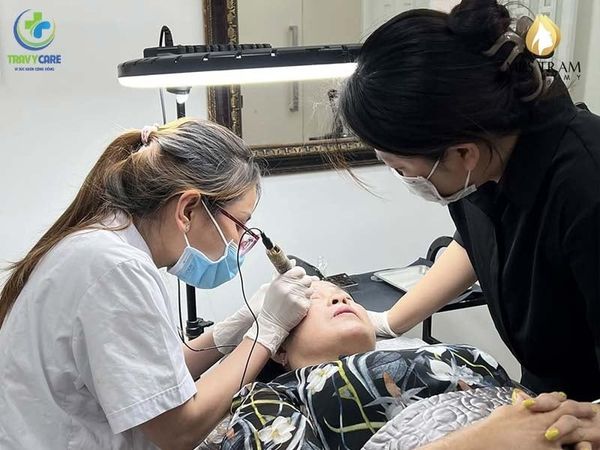 Học viên thực hành phun xăm chân mày dưới sự giám sát của giảng viên Miss Tram tại địa chỉ học phun xăm uy tín Travycare.