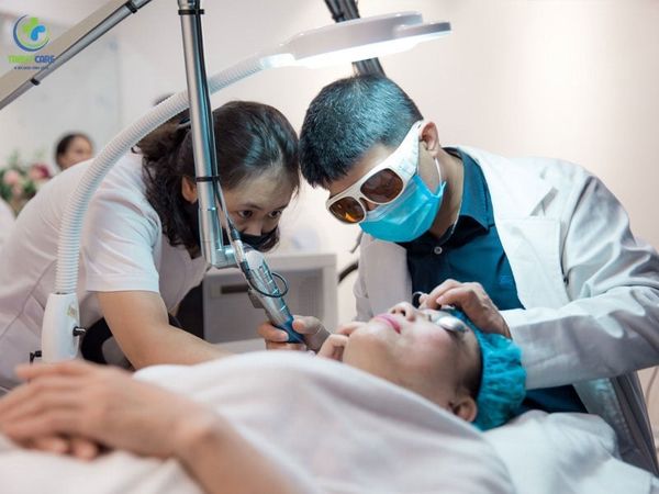 Bác sĩ da liễu đeo kính bảo hộ laser cẩn thận điều trị sắc tố cho bệnh nhân tại địa chỉ trị nám uy tín