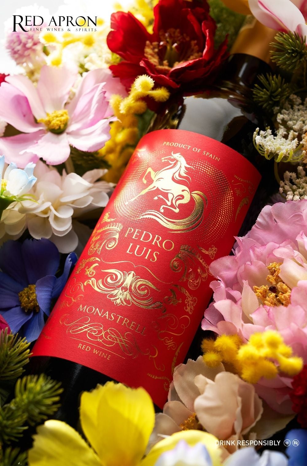 Chai rượu vang đỏ Pedro Luis Monastrell (Spain) đặt giữa hoa trang trí, gợi ý quà Tết cho bố mẹ.