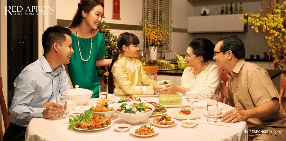 Gia đình nhiều thế hệ quây quần bên mâm cơm thịnh soạn, minh họa quà Tết cho bố mẹ là sự sum vầy.