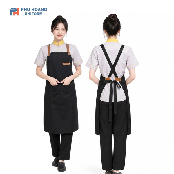 Tạp dề đen dây chéo chữ X, dây da nâu và tag da ở ngực.
