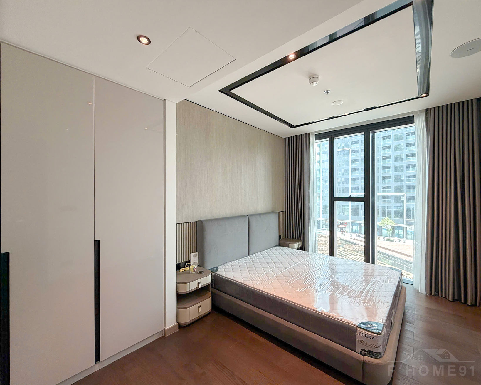 Cozy wooden floor bedroom inside a Grand Marina Saigon 1 bedroom apartment for lease.