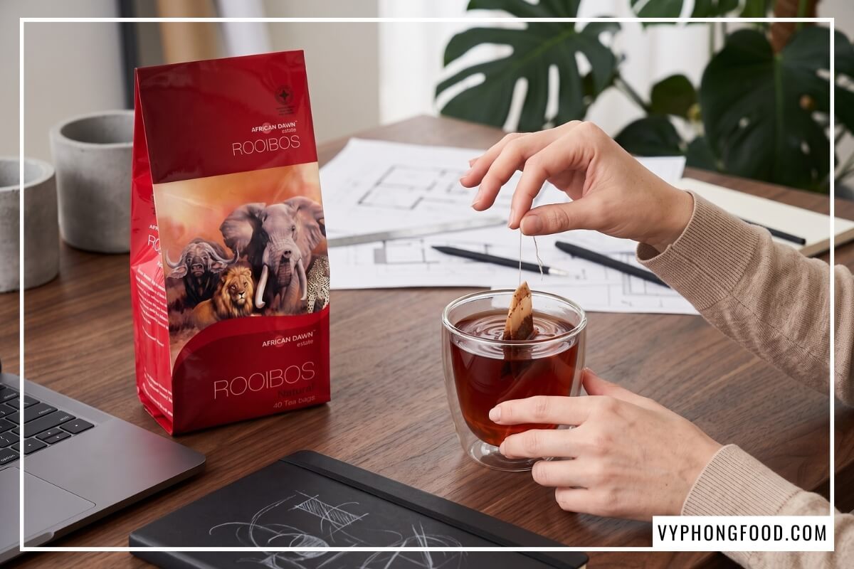 Gói hồng trà rooibos Nam Phi thương hiệu African Dawn màu đỏ đất trên bàn gỗ sồi tại địa chỉ bán trà rooibos chính hãng tại TP. Hồ Chí Minh.
