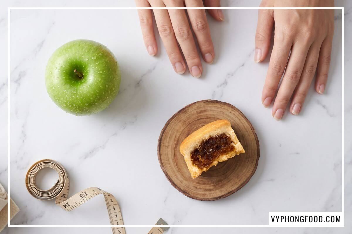 Khẩu phần bánh dứa mini Đài Loan 115 kcal đối xứng cùng quả táo xanh mọng nước trên nền đá cẩm thạch trắng.