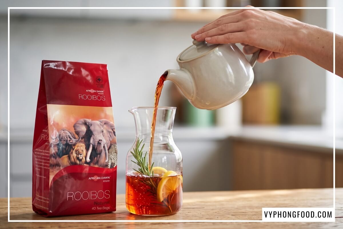 Rót ly hồng trà Nam Phi đỏ hổ phách cạnh hộp African Dawn giúp giải đáp trà rooibos có gây mất ngủ không.