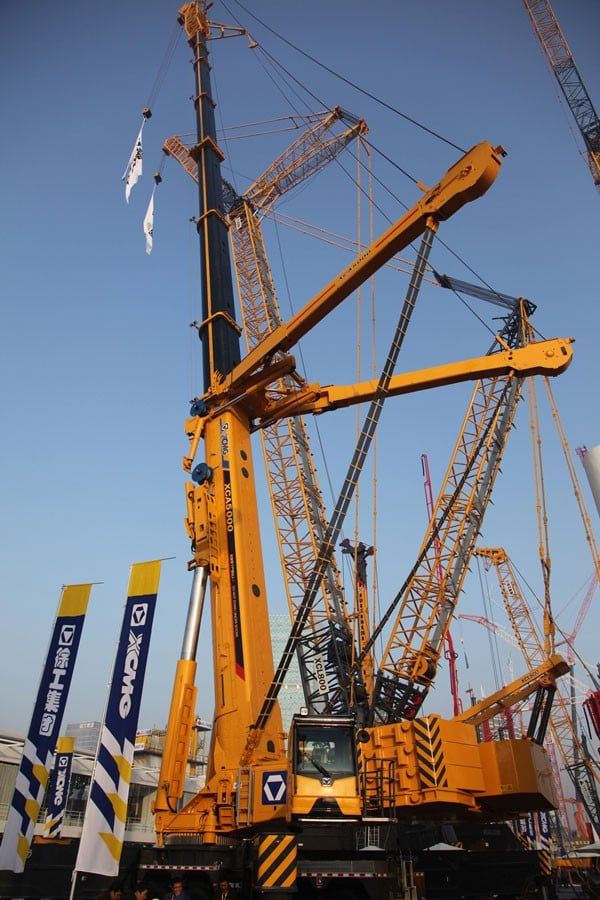 [Hình ảnh một xe cẩu bánh xích khổng lồ đang nâng cấu kiện thép tại công trường điện gió, thể hiện sự ổn định và tải trọng lớn]