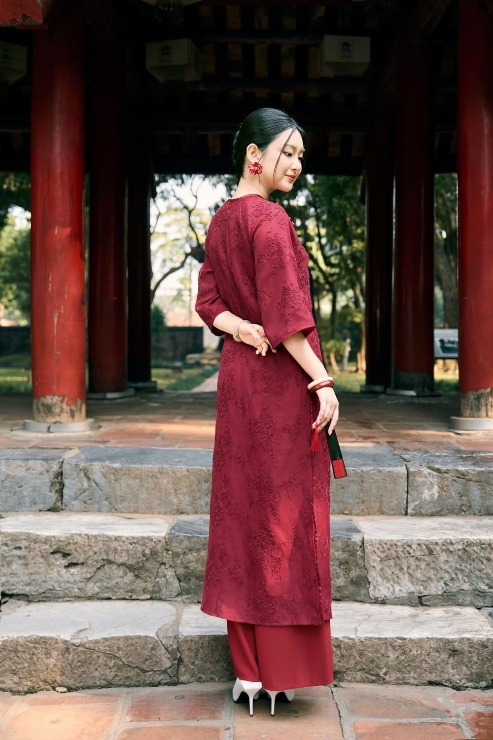 Đứng quay lưng lại, đầu ngoảnh nhìn sau, mắt nhìn theo vai, góc chụp toàn thân