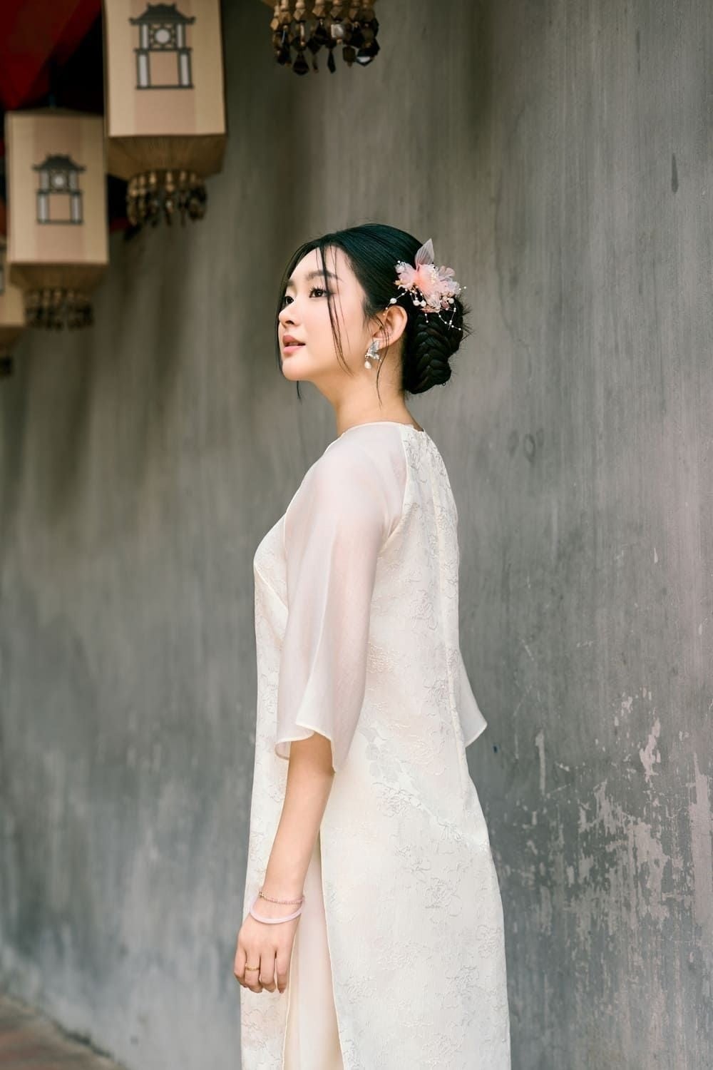 Đứng nhìn nghiêng, tay buông thõng, mắt nhìn về phía trước, góc chụp nghiêng một bên