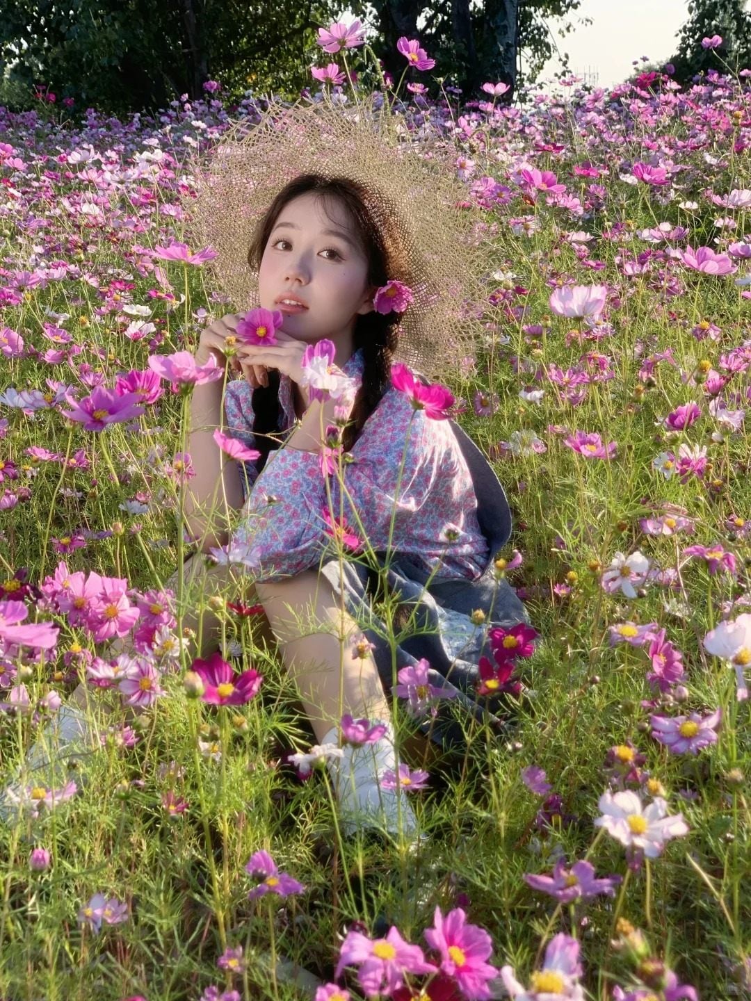 18. Tư thế ngồi trong biển hoa, tay nâng một bông hoa