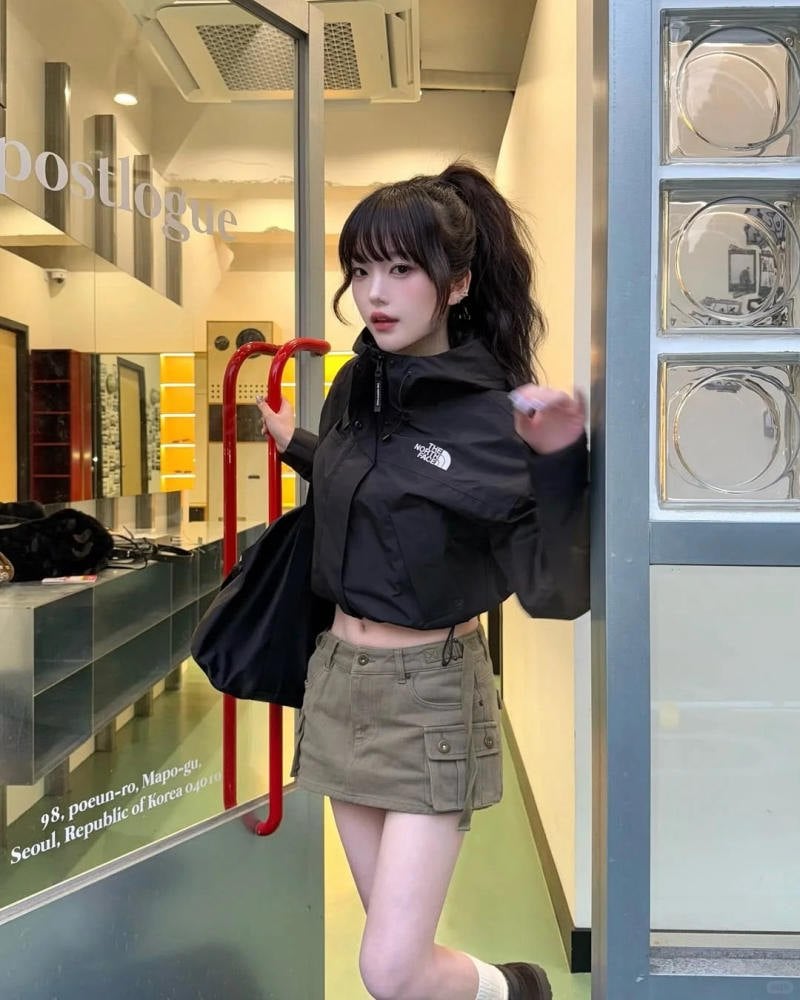 16. Áo khoác gió croptop đen + Chân váy kaki túi hộp + Tóc đuôi ngựa