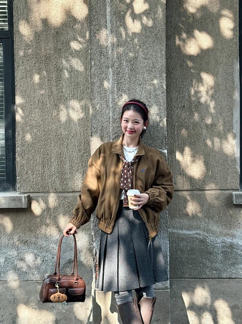 11. Áo khoác da lộn nâu + Chân váy xếp ly + Boots cao cổ