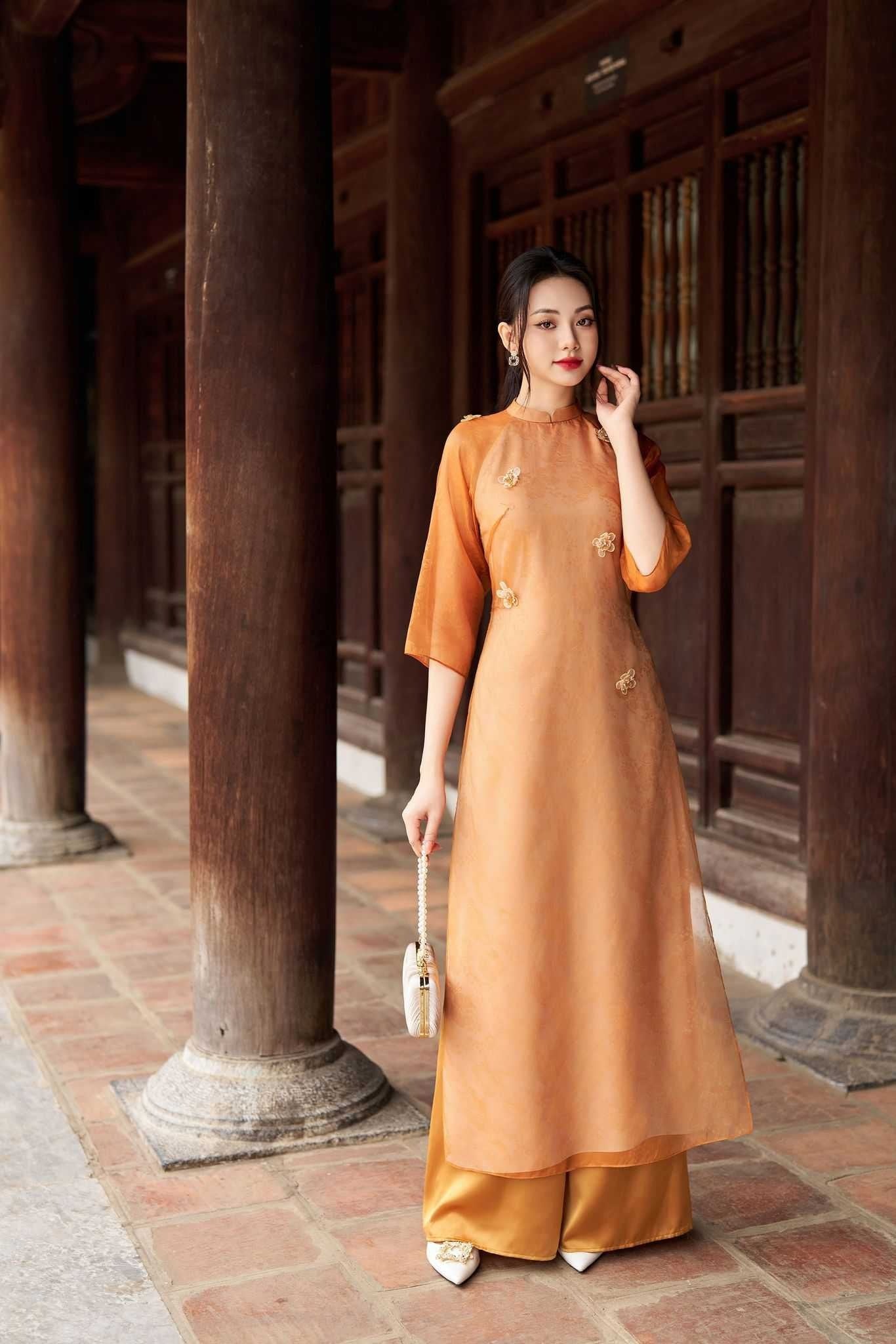 Mẫu 5: Áo dài tơ cam đất đính kết hoa mai