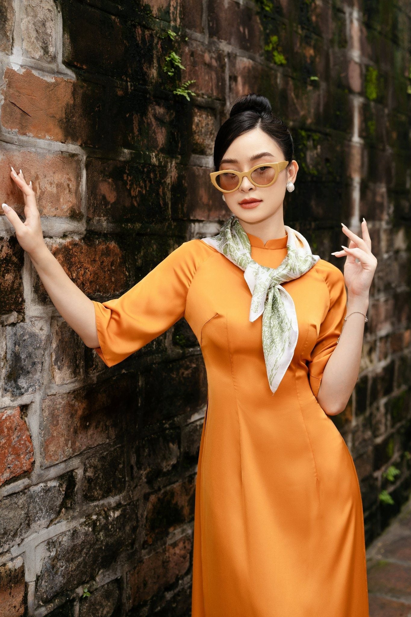 9. Áo dài lụa cam trơn kết hợp khăn lụa thời trang