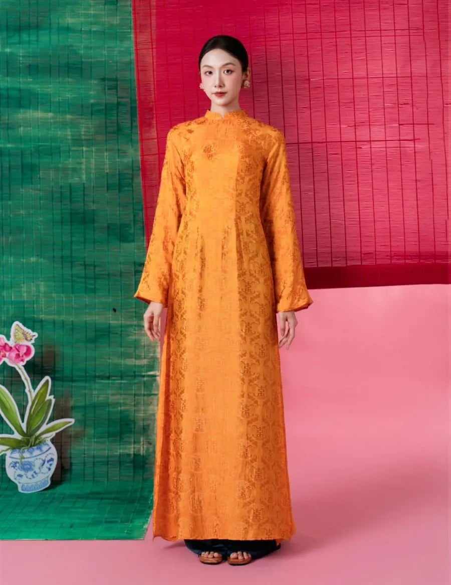 7. Áo dài gấm suông màu cam họa tiết chữ Thọ