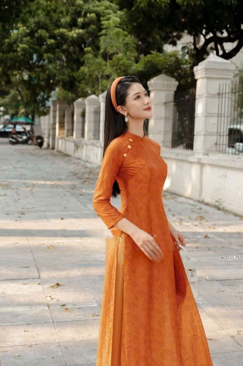 23. Áo dài gấm cam họa tiết lá chìm cổ điển