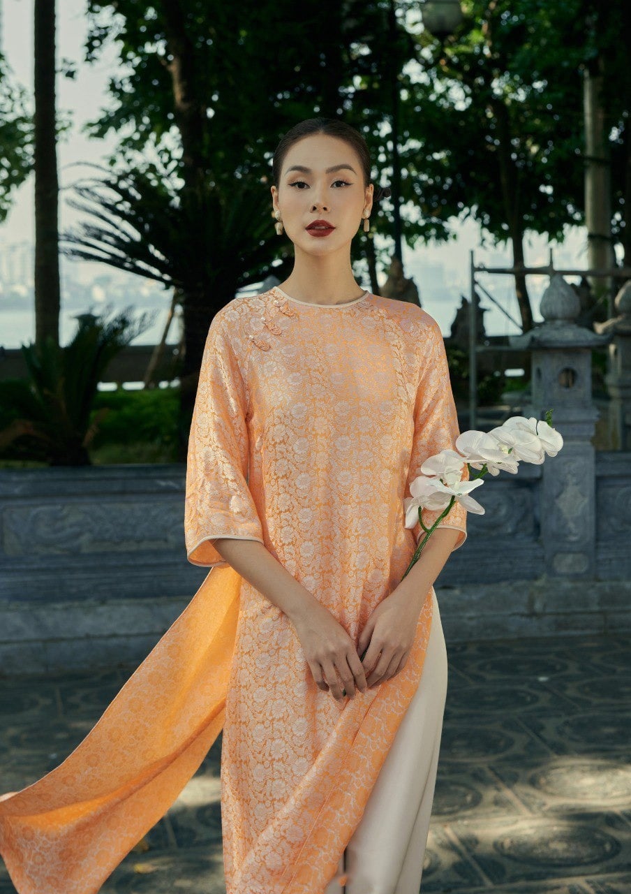 14. Áo dài gấm suông màu cam phấn họa tiết hoa cúc