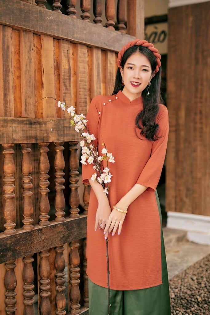 30. Áo dài đũi màu cam đất đính ngọc trai chéo vai