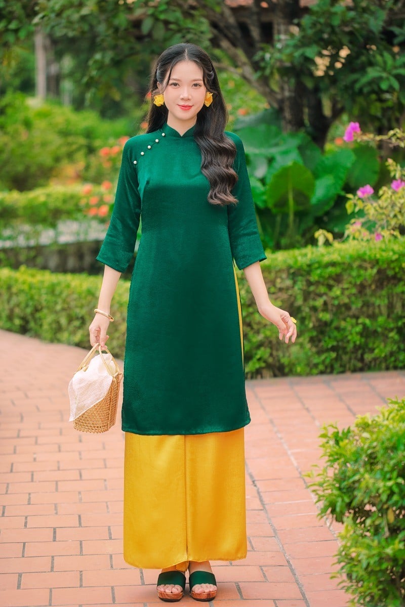 21. Mẫu áo dài nhung xanh đậm phối quần vàng