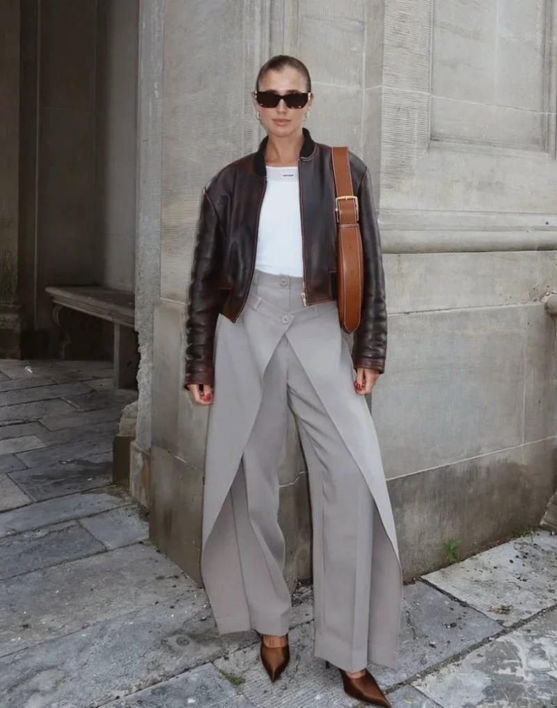 Quần ghi ống rộng xẻ tà + Áo thun trắng + Áo khoác da nâu