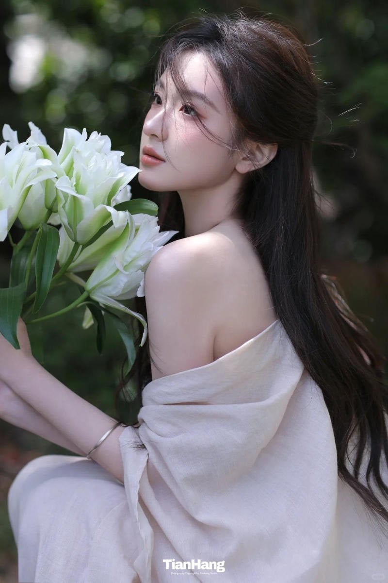 25. Tư thế ngồi xổm, ghé mặt vào hoa