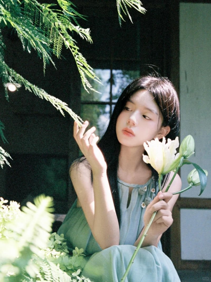 9. Tư thế ngồi bên hiên nhà, tay chạm lá