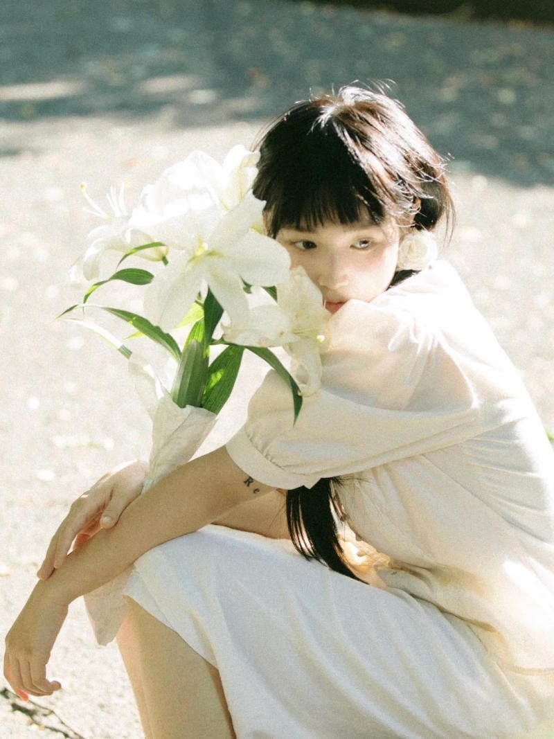 12. Tư thế ngồi co người, dùng hoa che mặt