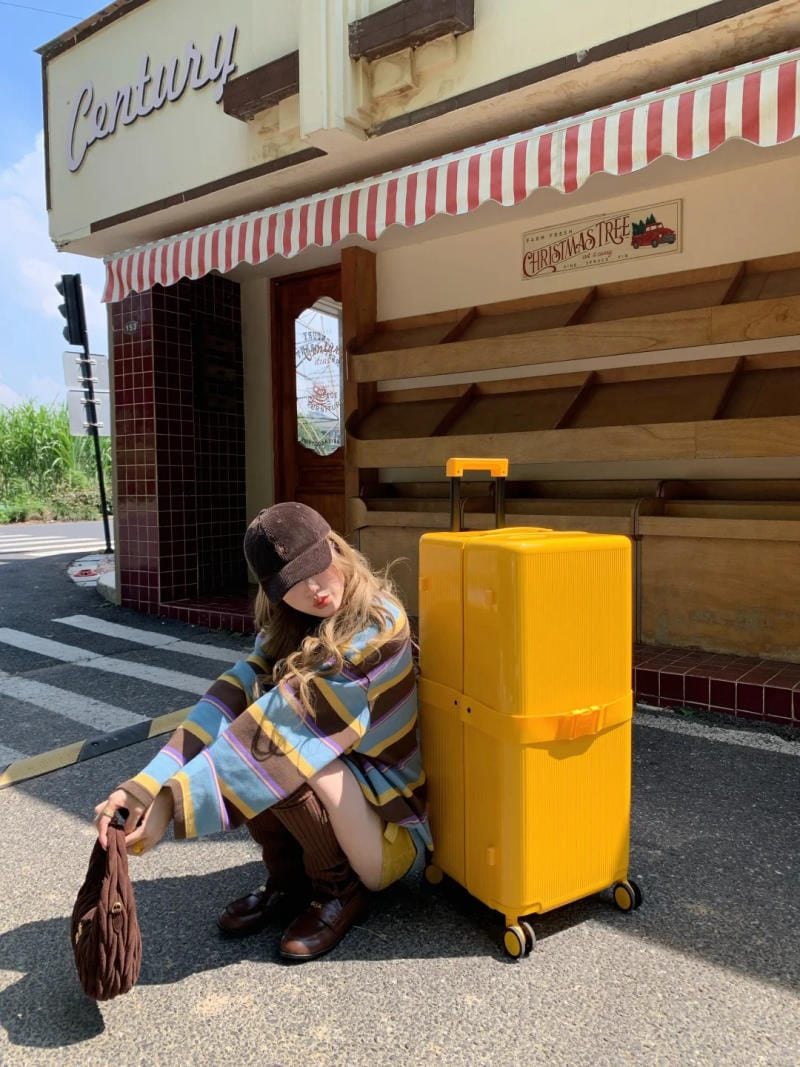 Ngồi nghỉ chân trên vali bên một quán cafe vỉa hè